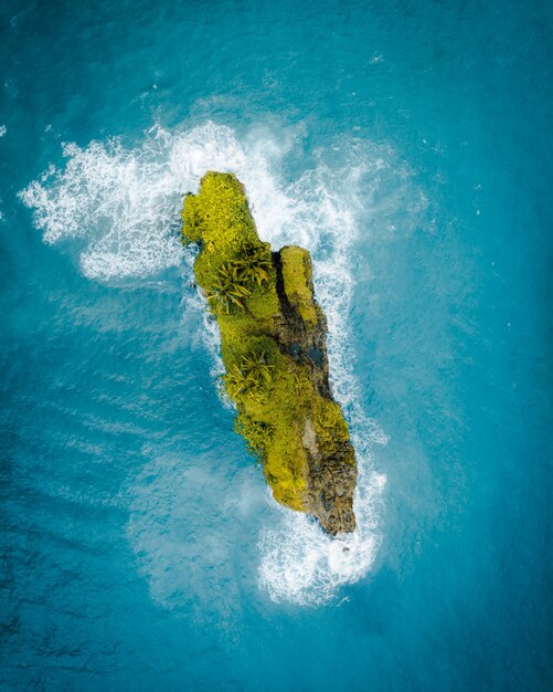 Aerial shot of a beautiful green little island in the middle of the ocean