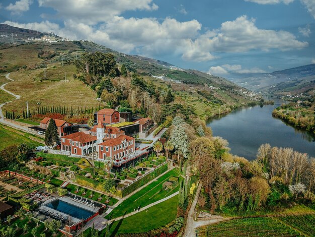 Aerial shot of a beautiful lake and a forest with a small residency in the middle