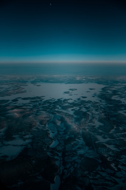 Aerial shot of a beautiful landscape covered with snow in the early morning