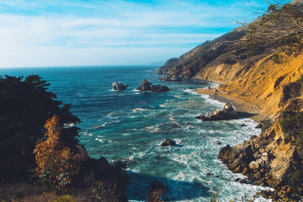 Aerial shot of the beautiful ocean with rocky steep cliffs on both sides