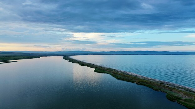 Aerial shot of the beautiful sea with a thin narrow coastline in the middle