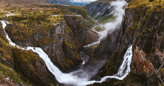 Aerial shot of the beautiful waterfalls over the mountains captured in Norway