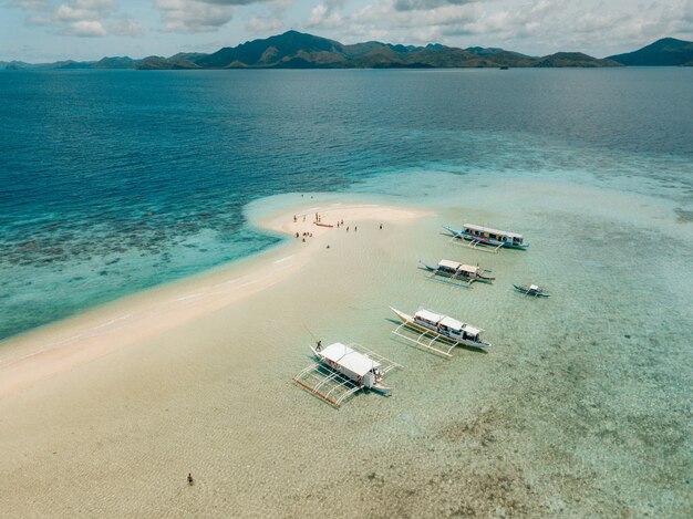 Aerial shot of the boats on the calm crystal clear ocean
