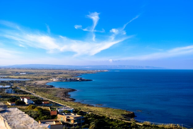 Aerial shot of buildings near the sea under a blue sky at daytime