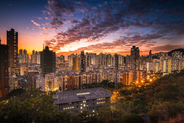 Aerial shot of city skyline under an orange sky at sunset