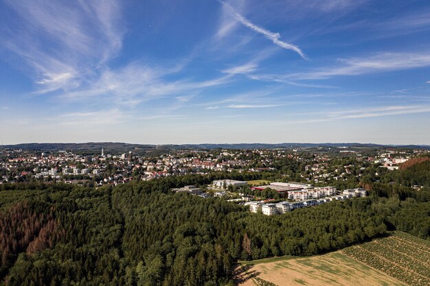 Aerial shot of a cityscape in a landscape covered with trees
