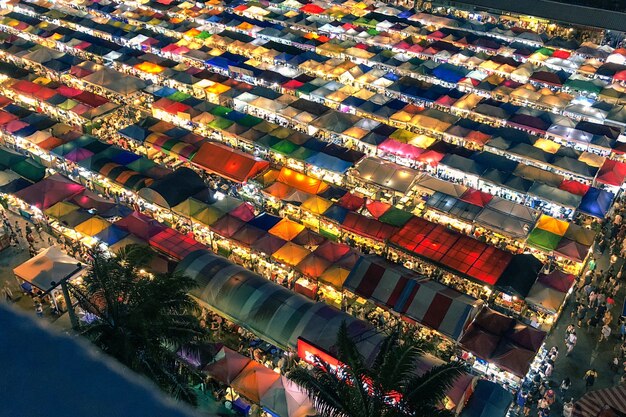 Aerial shot of colorful market tents with lit lights at night time