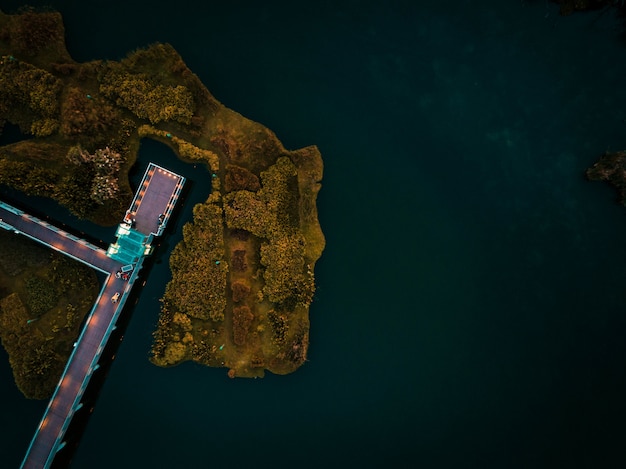 木の島に囲まれた海の上のドックの空中ショット