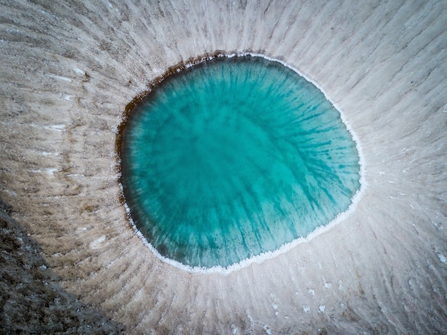 Aerial shot of frozen volcano crater and ice lake in kamchatka, russia