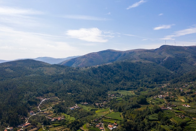 Aerial shot of houses on the green hills and valley