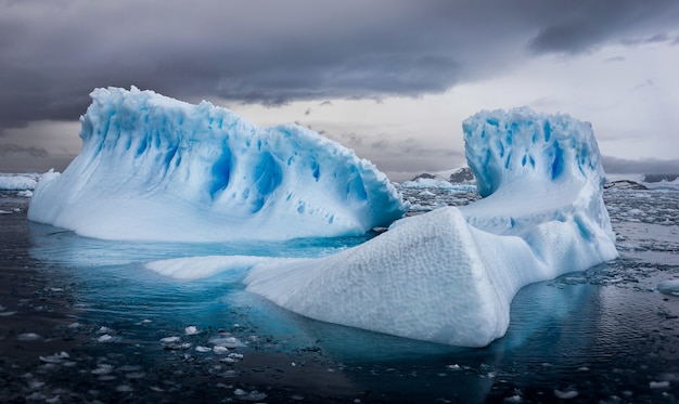 Aerial shot of icebergs in Antarctica under cloudy sky