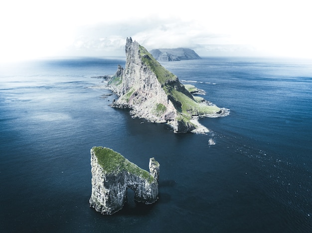 Free photo aerial shot of islets in the middle of sea under cloudy sky