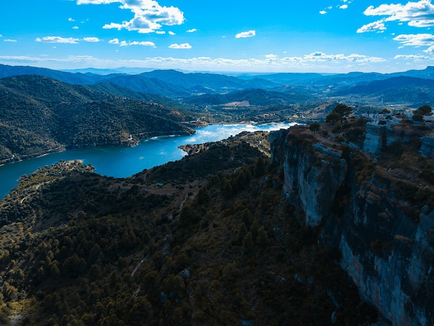 Aerial shot of a lake on top of the mountain with blue sky on the background