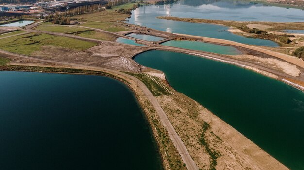 Aerial shot of a landscape surrounded by mountains and lakes with industrial disaster