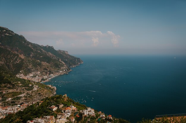 Aerial shot of a landscape with buildings on the coast of the sea in Italy