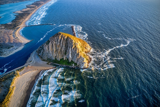 Aerial shot of the Morro Rock in California at sunset