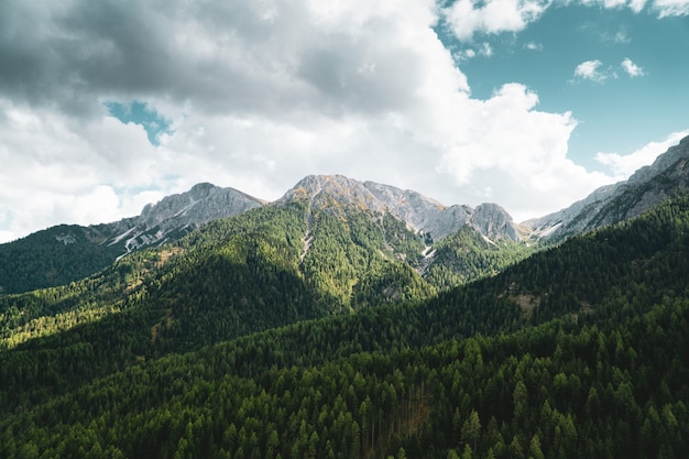 Free photo aerial shot of mountains under blue sky and white clouds