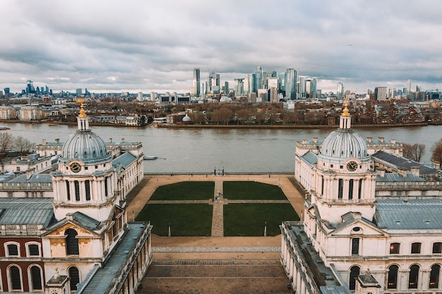 Aerial shot of the National Maritime Museum in Greenwich with a river and city skyline