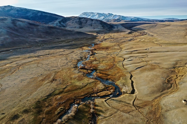 Aerial shot of a river in a big dry grassland