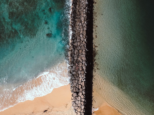 昼間の海の岩だらけの小道の空中ショット