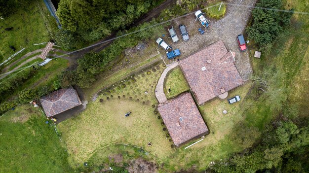 車と緑の植物のある建物の屋根の空中ショット