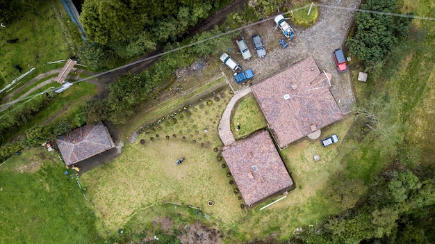 Aerial shot of a roof of a building with cars and green plants