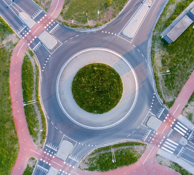 Aerial shot of a roundabout surrounded by greenery under the sunlight at daytime