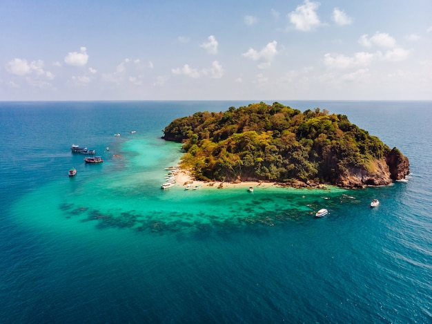 Aerial shot of a small green island in the middle of the ocean