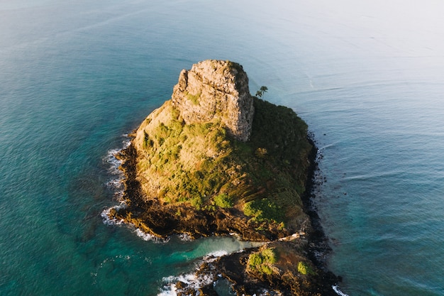 Aerial shot of a small island in the blue ocean during daytime