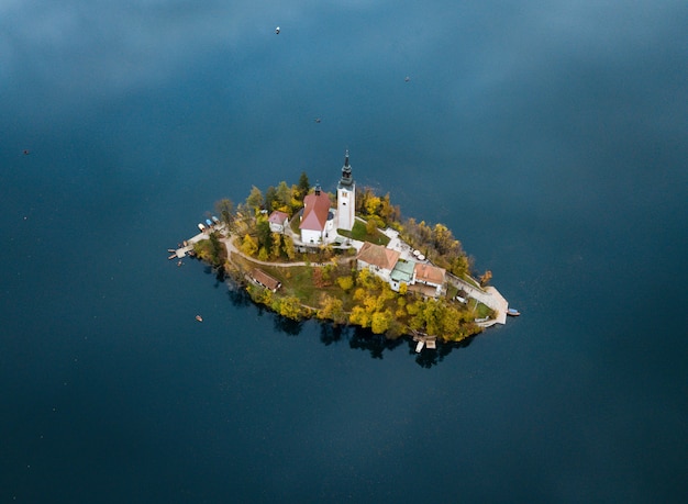 Aerial shot of a small island with houses in the middle of the ocean