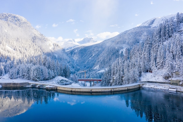 Aerial shot of the snow-capped mountains with a calm lake at daytime