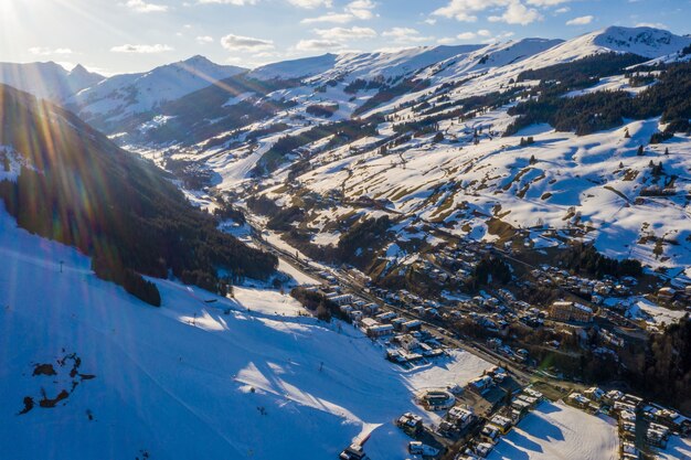 Aerial shot of a snowboarding resort in the snow under the sunlight