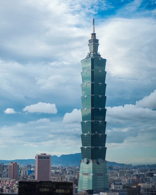 Aerial shot of a tall skyscraper under the beautiful cloudy sky