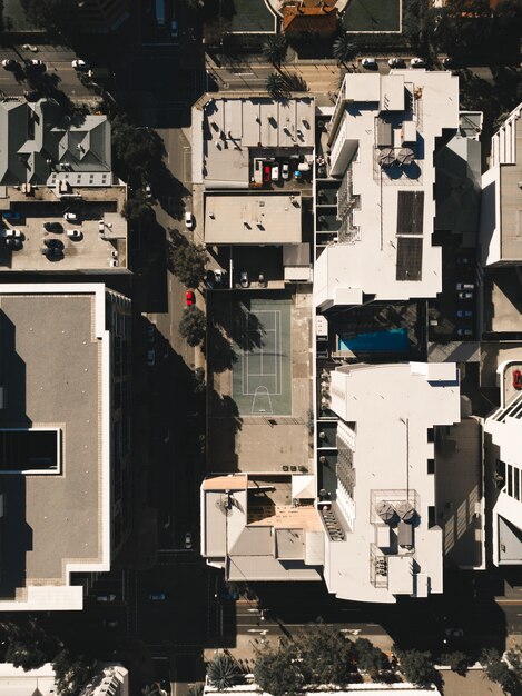 Aerial shot of a town with high buildings and a tennis court