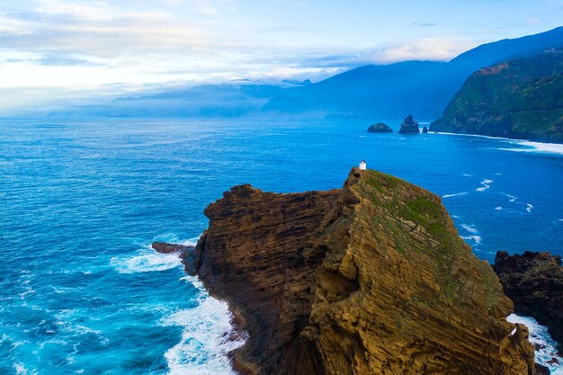 Aerial shot of waves from the sea crashing on stone formations