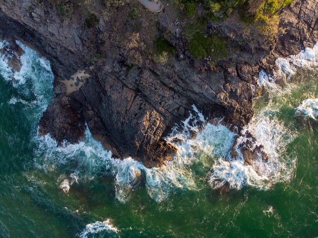 Aerial shot of waves hitting a cliff