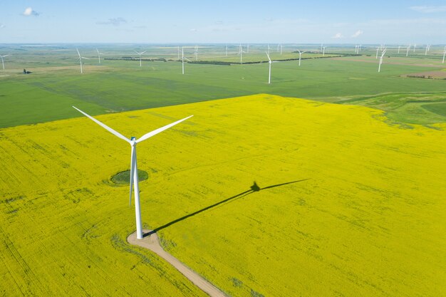 Aerial shot of wind generator in a large field during daytime