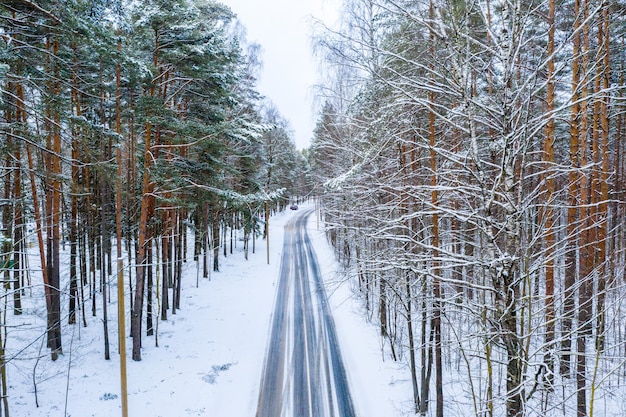 Aerial shot of winter road through the forest