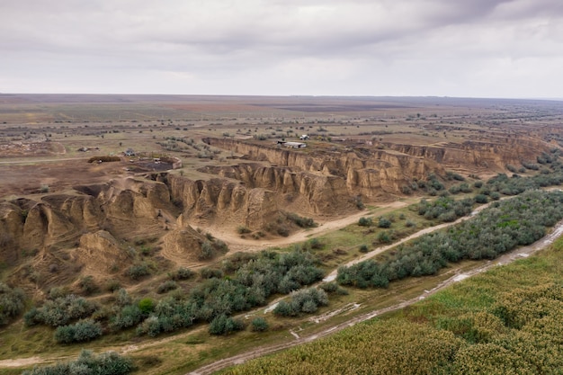 Бесплатное фото Вид сверху с воздуха на сельскую дорогу, разделяющую мельницу и песчаные дюны.