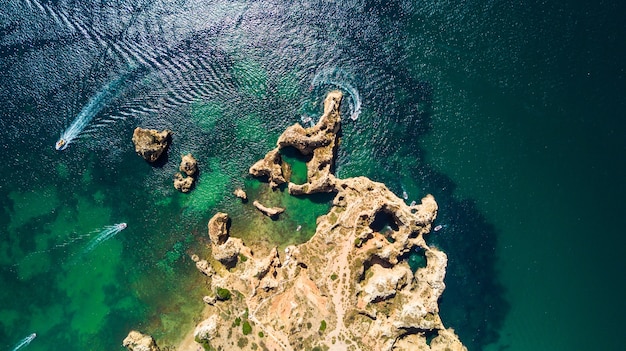 Вид сверху на живописный Понта-да-Пьедаде в Лагуше, Португалия. Прочные приморские скалы и морские воды океана в регионе Алгарве в Португалии