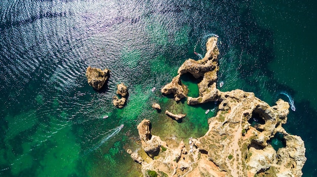 Aerial top view of Scenic Ponta da Piedade of Lagos, Portugal. Rugged seaside cliffs and aqua ocean waters in the Algarve region of Portugal