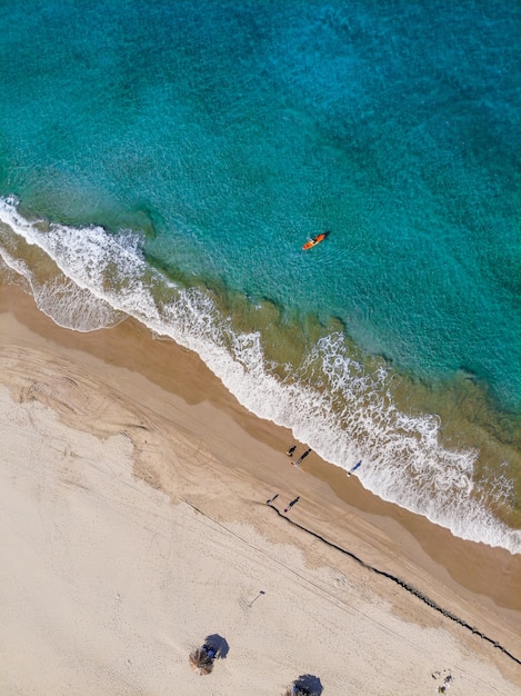 Foto gratuita colpo verticale aereo della gente sulla riva della spiaggia di giorno