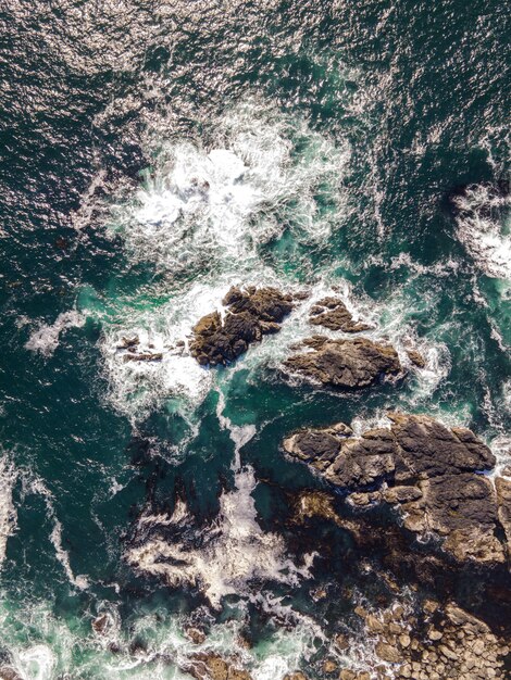 Aerial vertical shot of a sea with rocky stones