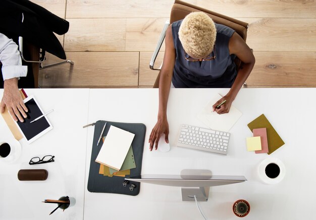 Aerial view of african descent woman working on computer on white table at office