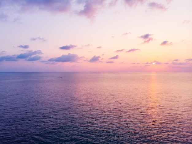 Aerial view of beautiful beach and sea with coconut palm tree at sunset time