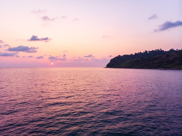 Aerial view of beautiful beach and sea with coconut palm tree at sunset time