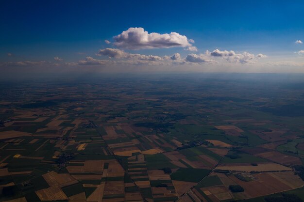 Aerial view of the blue sky with white clouds floating above the fields