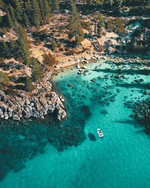 Free photo aerial view of a boat on the water at the rocky beach