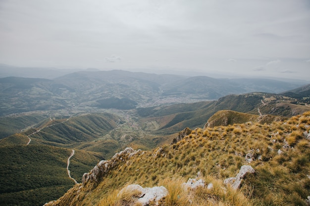 Aerial view of a countryside road passing through the trees and mountains