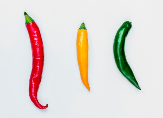 Free photo aerial view of fresh red green yellow chili peppers on white background